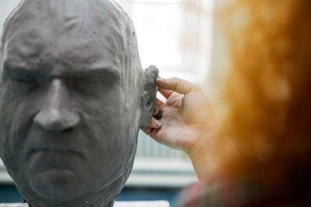 istock Young redhead woman working on a head sculpture ear 1304380634