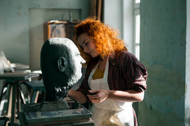 istock Redhead woman working on a head sculpture 1304380640