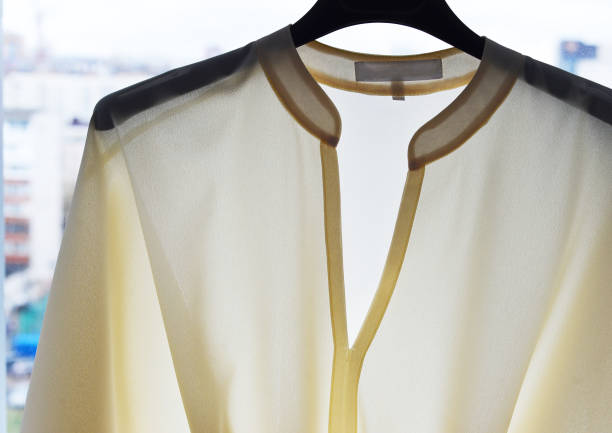 istock A blouse with a light in the window hangs on a hanger. The seams show through. 1304381085