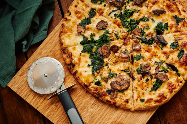 istock Overhead view of a sliced Spinach and Mushroom pizza. 1304384831