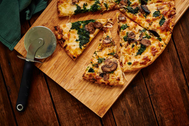 istock Overhead view of a sliced Spinach and Mushroom pizza. 1304384837