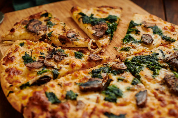 istock Close up of a sliced Spinach and Mushroom pizza. 1304384840