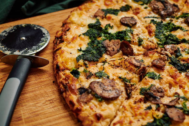 istock Close up of a sliced Spinach and Mushroom pizza. 1304384856