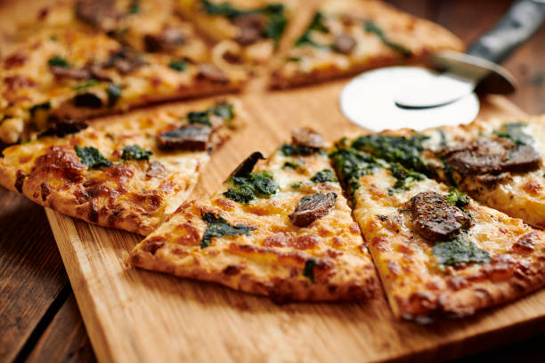 istock Close up of a sliced Spinach and Mushroom pizza. 1304384865