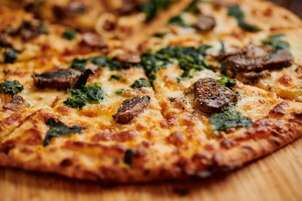 istock Close up of a sliced Spinach and Mushroom pizza. 1304384868