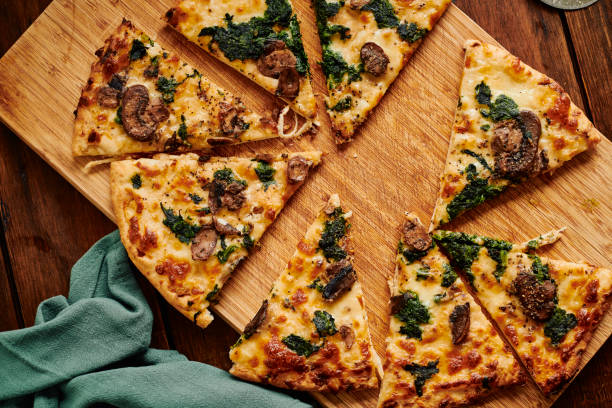 istock Overhead view of a sliced Spinach and Mushroom pizza. 1304384874