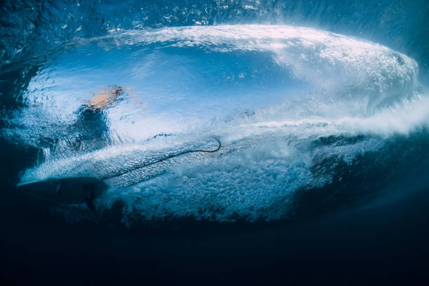 istock Wave with surfer under water. Surfer ride on wave, view from underwater 1304386506