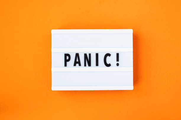 istock Lightbox with a words text Panic board on orange background. Concept panic mood during quarantine period, pandemic of coronavirus. 1304391264