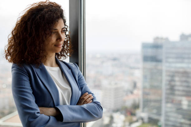 istock Young thoughtful businesswoman looking through window 1304391765