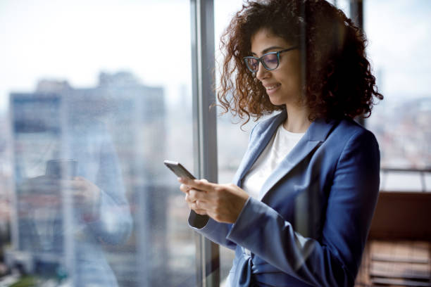 istock Young businesswoman using smart phone in office 1304392419