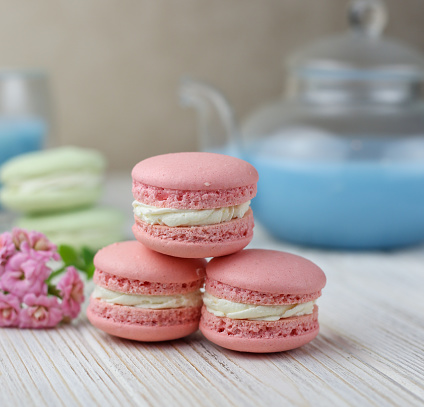 Pink macaroons with the glass pot of blue masala tea. High quality photo