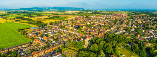 panorama aéreo sobre casas suburbanas rodeadas de tierras de cultivo de campos verdes - vale of evesham town worcestershire midlands fotografías e imágenes de stock