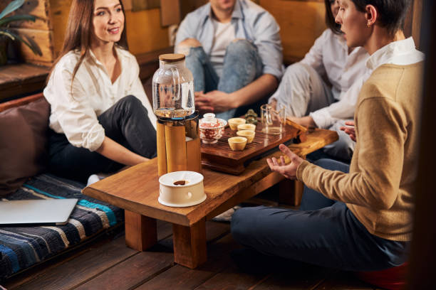istock Young people communicating during tea ceremony in cozy cafe 1304398476