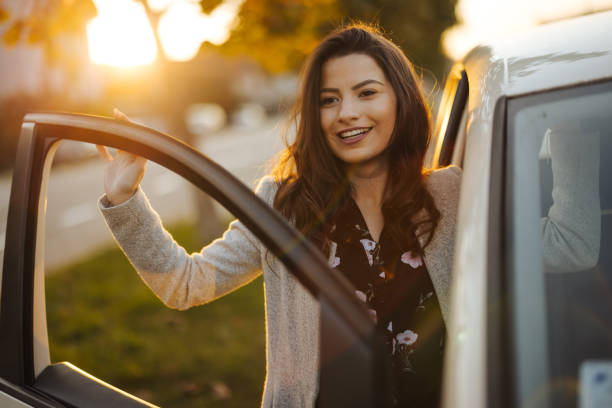 istock Young woman getting into car in town 1304401473