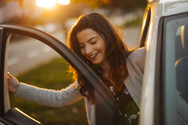 istock Young woman getting into car in town 1304402229