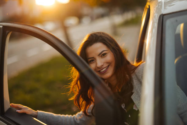 istock Young woman getting into car in town 1304402398