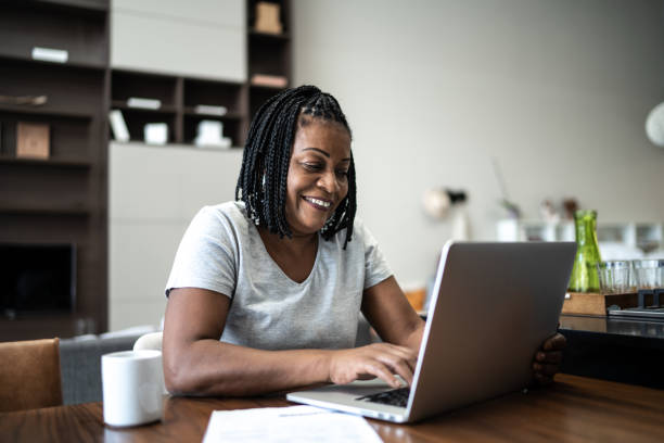 istock Mature woman using laptop working from home 1304403816