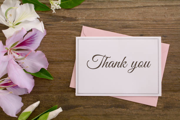 Thank you card with flowers A thank you card on a pink envelope, with pink and white flowers on rustic wood background.
Shot from above. gift tag note stock pictures, royalty-free photos & images