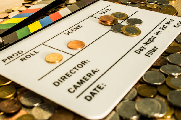 clapperboard com moedas acima e sobre ele criando uma relação entre cinema e negócios - hollywood movie - fotografias e filmes do acervo