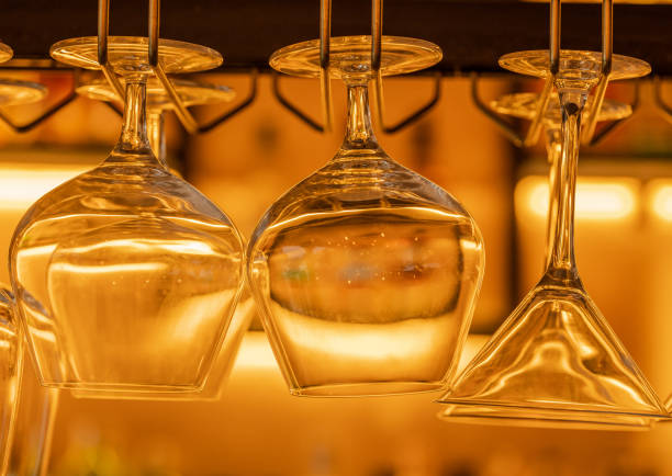 istock Hanging wine glasses in a bar with beautiful warm lighting 1304408803