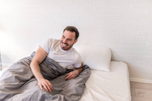istock Happy man waking up fully rested in the morning. 1304410034