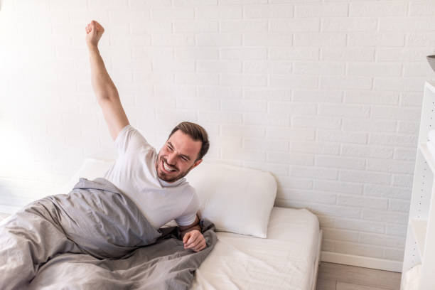 istock Happy man waking up in his bed. 1304410125