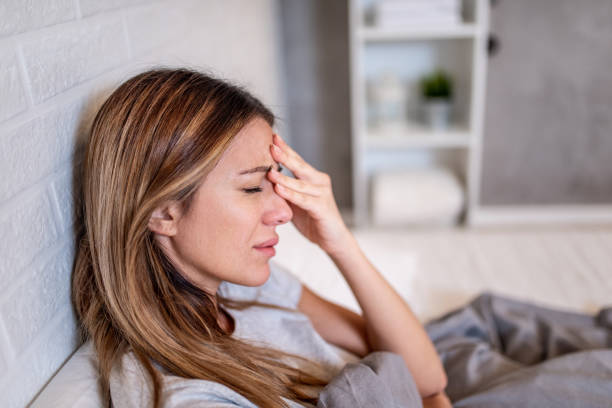 istock Young woman laying in bed with a headache. 1304410556