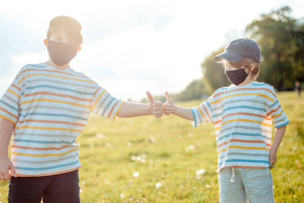 istock Two boys are running in the meadow, Protective mask, Covid-19 1304411544