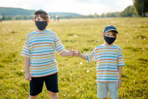 istock Two boys are running in the meadow, Protective mask, Covid-19 1304411588