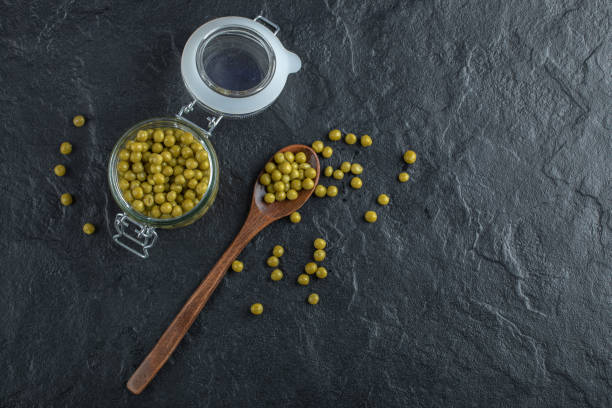 istock Green marinated olive in jar and ground Over black background 1304411912