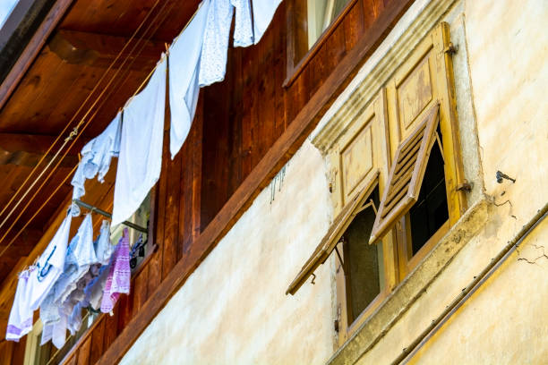 Italian house, laundry drying on clothesline and shutter window somewhere in Italy, rural or urban alike