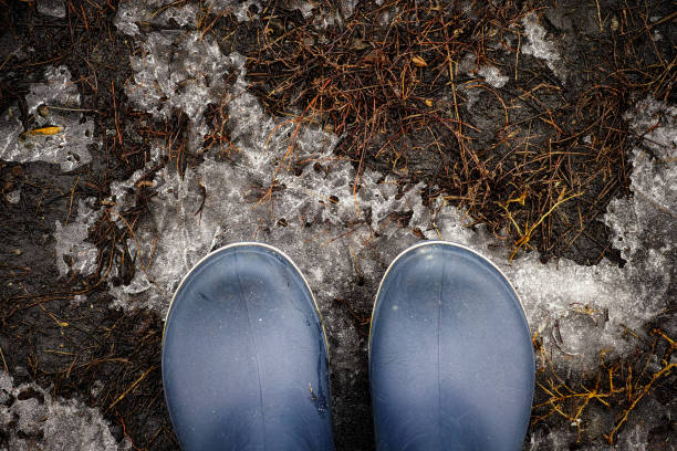 istock Person in boots standing on standing on patch of ice 1304420659