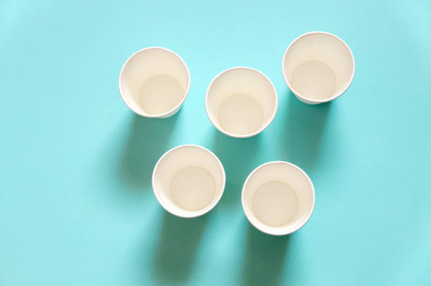 istock disposable white kraft paper cups stand on paper blue background 1304421622