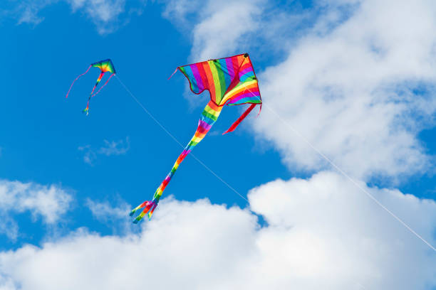 istock Two colorful kites in a blue sky with white clouds 1304421698