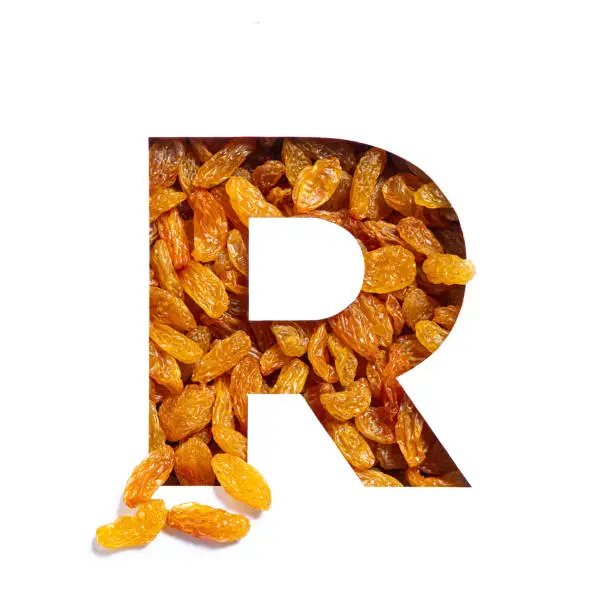 Letter R of English alphabet made of raisins and paper cut isolated on white. Typeface from dried berries. High quality photo