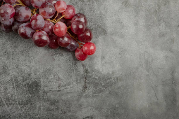 istock Cluster of red fresh ripe grapes on marble surface 1304422853