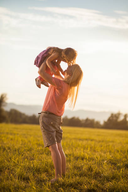 istock Mother lifting her girl on a summer evening 1304426127