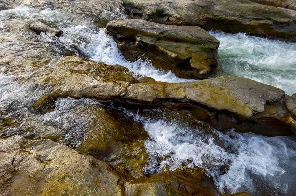 istock River water flowing among brown rocks 1304428985