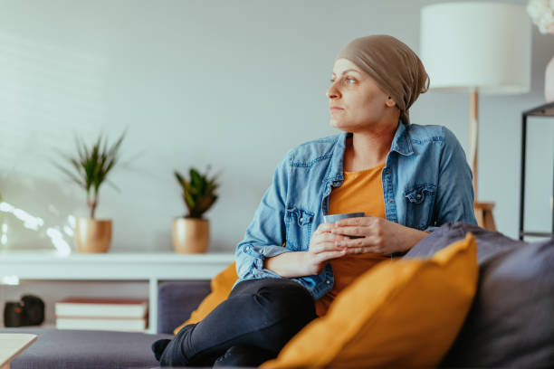 cancer patient looking far, wearing headscarf - cancer chemotherapy drug patient women imagens e fotografias de stock