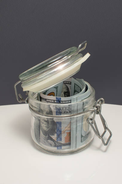 istock dollar bills in Glass jar for money 1304429160