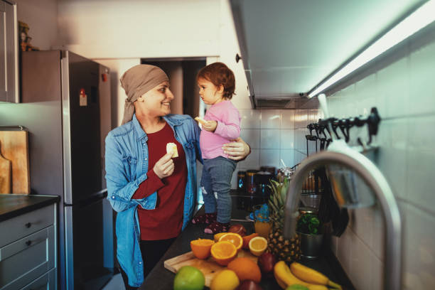 madre guarita dal cancro che fa colazione con la figlia - cancer chemotherapy drug baby family foto e immagini stock