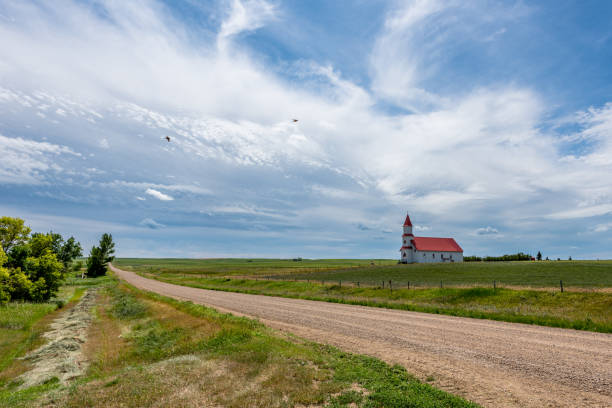 캐나다 서스캐처원 빌리문에 있는 역사적인 성 마틴 로마 가톨릭 교회로 이어지��는 자갈 길 - saskatchewan country road road prairie 뉴스 사진 이미지