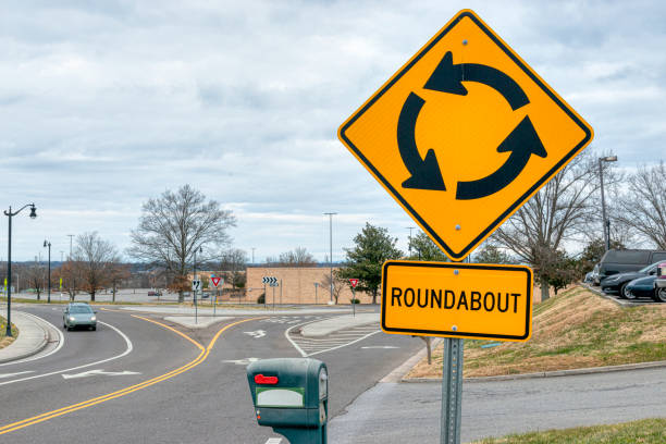 panneau de rond-point de circulation avec la circulation approchante (véhicule déguisé) - traffic roundabout photos et images de collection