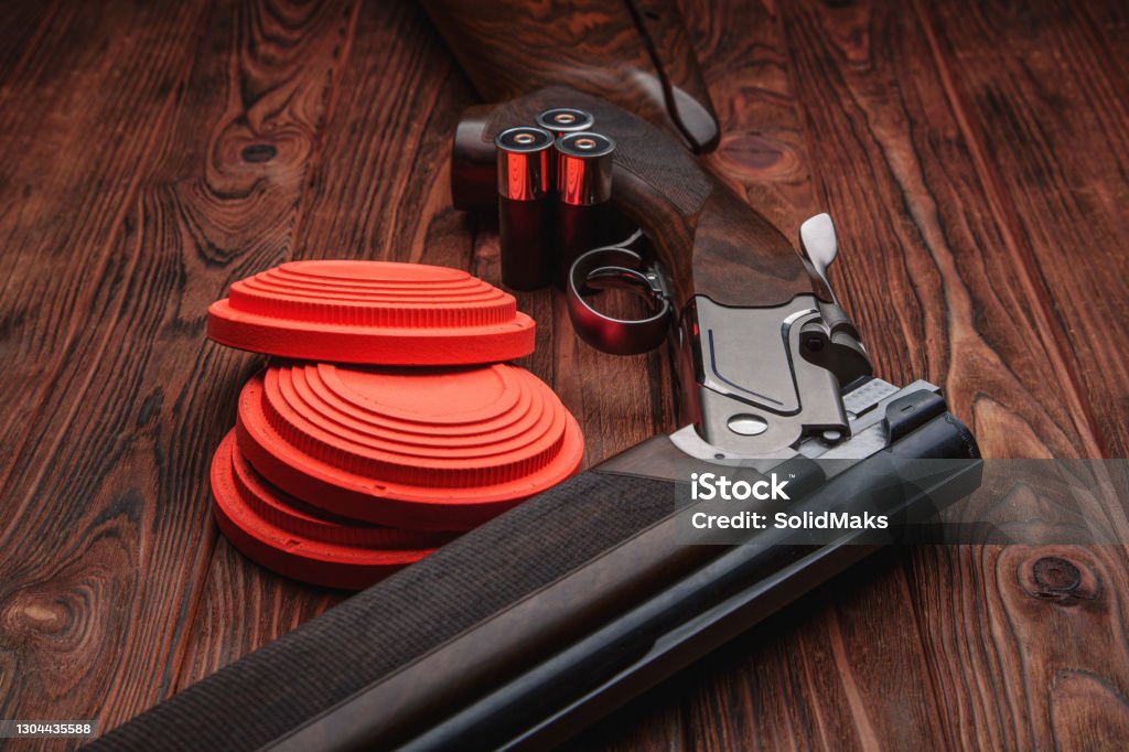 Clay target plates for shooting with rifle on wooden background. Skeet Shooting Stock Photo