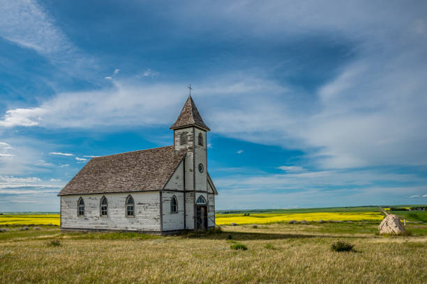 Side view of Peace Lutheran Church in Stonehenge, SK Side view of the historic, yet abandoned Peace Lutheran Church in Stonehenge, SK with a canola field and countryside in the background protestantism photos stock pictures, royalty-free photos & images