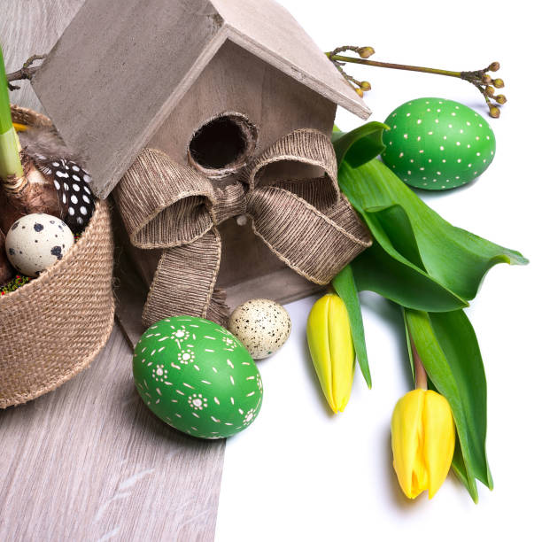istock Easter banner with birdhouse, yellow tulips and Easter eggs. Natural decorations, low impact handmade decor from biodegradable materials and natural flowers 1304438613
