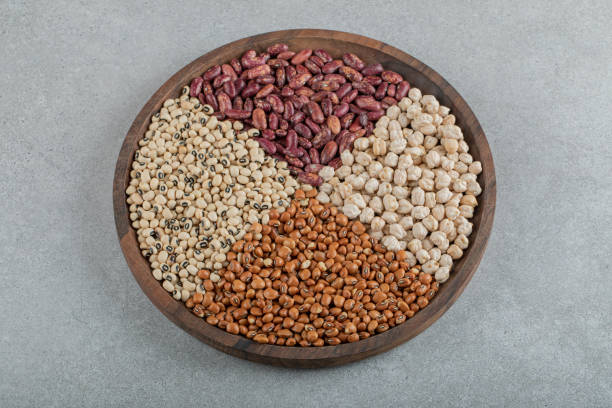 istock A wooden plate with various raw beans on a gray background 1304447271