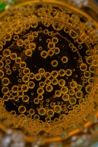 istock Yellow juice with bubbles on black background 1304456618