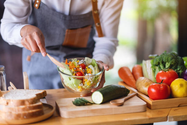 istock a female chef cooking fresh mixed vegetables salad in kitchen 1304459953