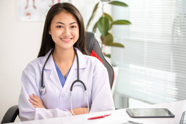 istock Young woman doctor smiling at office 1304465928